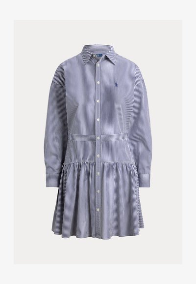 Μπλε και λευκό κάθετα ριγέ φόρεμα με μακριά μανίκια, κουμπιά μπροστά, γιακά, φούστα με πιέτες και κεντημένο λογότυπο στο στήθος.