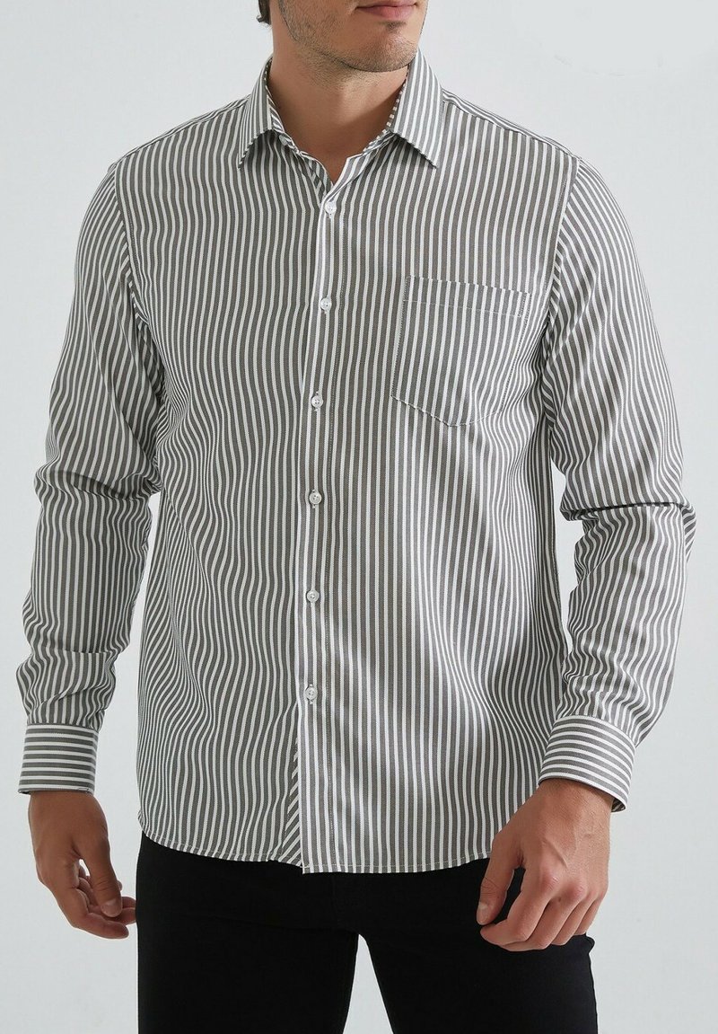 Chemise à rayures grise et blanche, à manches longues, avec un col classique et une poche poitrine unique. Tissu en mélange de coton.