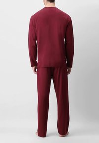 Top a maniche lunghe color bordeaux e pantaloni abbinati, realizzati in un tessuto morbido. Il top presenta un collo a giro, mentre i pantaloni hanno una vestibilità comoda.