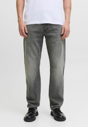 Lichtgrijze denim jeans met een rechte pasvorm, voorzien van lichte slijtage, vijf zakken en gecombineerd met zwarte schoenen.