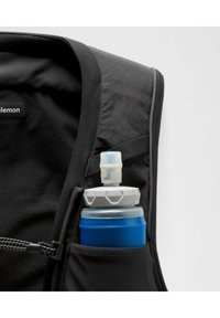 Chaleco negro con un bolsillo lateral que contiene una botella de agua azul, con una tapa gris y una pajilla. La tela presenta una textura transpirable.