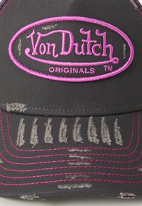 Crna kapa s ružičastim izvezenim logotipom "Von Dutch Originals". Imazak na obodu s istrošenom teksturom i kontrastnim šavovima.