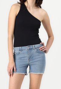 Černý žebrovaný top na jedno rameno v kombinaci s světle modrými denimovými šortkami s třepeným lemem a klasickým designem pěti kapes.