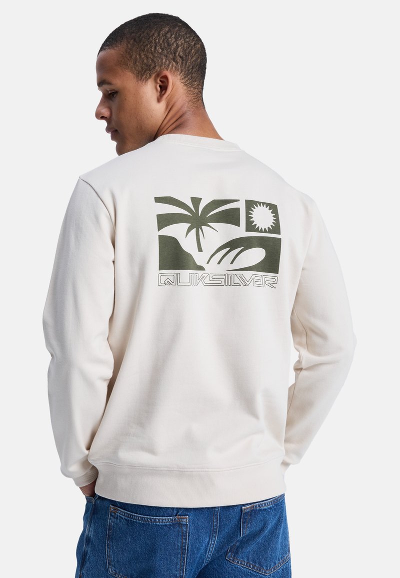 Sudadera de color crema con mangas largas, que presenta un diseño gráfico verde de palmeras y un sol en la parte posterior. Puños y dobladillo acanalados.