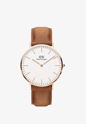 Rjav usnjen pasovni ura z zlatim ohišjem, belim številčnicam, minimalističnimi oznakami ur in logotipom "Daniel Wellington".