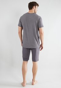 Herren-Loungewear-Set mit einem grau-weißen gestreiften Kurzarmhemd und einfarbigen grauen knielangen Shorts, aus leichtem Stoff hergestellt.