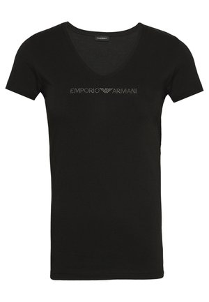 Black short-sleeve t-shirt with a v-neck. Features "EMPORIO ARMANI" in metallic studs across the chest. Soft fabric texture.