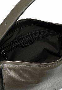 Olivgrüne Lederhandtasche mit einem Reißverschluss-Hauptfach. Sie verfügt über eine glatte Textur und ein Innenfach mit schwarzem Futter und Reißverschluss.