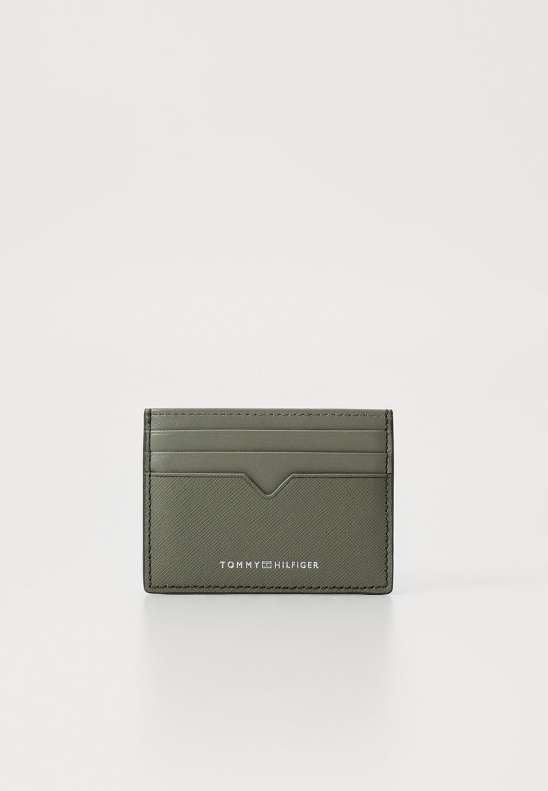 Cardholder sintetic verde, cu multiple compartimente, finisaj texturat și logo embossat. Prezentând un accent triunghiular subtil în partea de sus.