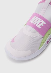 Nike αθλητικά παπούτσια με ελαφρύ ροζ δικτυωτό πάνω μέρος, ροζ λουράκι με το λογότυπο "NIKE", πράσινα στοιχεία και στρογγυλή μύτη.