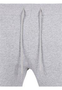 Grå sweatpants med ribbat midjeband, dragskor och en mjuk tygtextur. Inga synliga mönster eller logotyper.