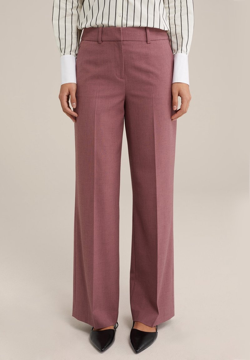 Vidbenade byxor i ett ljust mauve-tyg, med en slät textur, framfickor, en skräddarsydd midja och svarta spetsiga klackar.