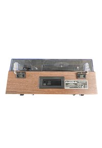 Tocadiscos de madera con cubierta de plástico transparente, que cuenta con puertos de salida de audio y una etiqueta de advertencia. Superficie lisa, diseño rectangular.