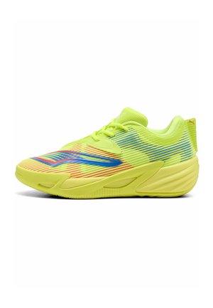 Zapatilla deportiva de color amarillo brillante con detalles a rayas azules y rojas y suela amarilla a juego, vista de lado.