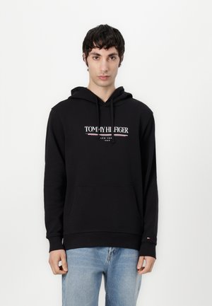 Black hoodie made of soft fabric, featuring a front kangaroo pocket and drawstring hood. Logo displayed prominently on the chest.