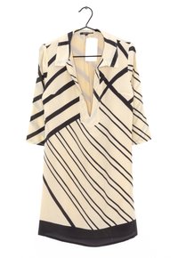 Beige Bluse mit schwarzen diagonalen Streifen, kurzen Ärmeln und V-Ausschnitt. Verfügt über einen Kragen und eine kleine Brusttasche. Glatte Stoffoberfläche.