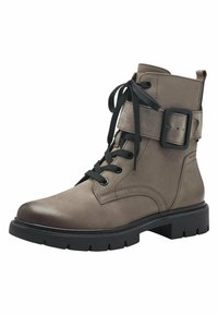 Botte courte en cuir marron avec une texture lisse, lacets noirs, détails de boucle et semelle en caoutchouc robuste, dotée d'un embout légèrement pointu.