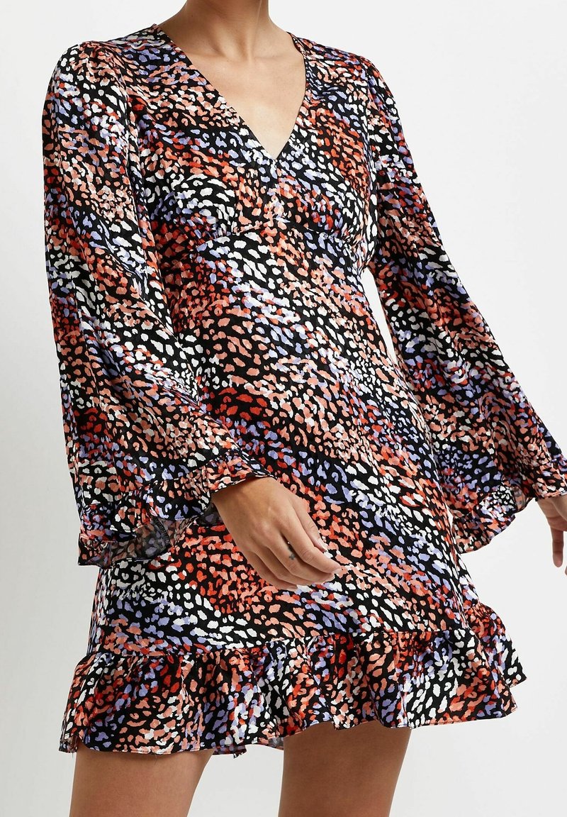 Robe à manches courtes avec un décolleté en V et un ourlet évasé à volants. Elle présente un imprimé animalier multicolore sur fond noir.