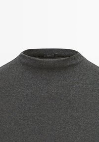 Dunkelgrauer gerippter Strickpullover mit Rollkragen und einem kleinen schwarzen Etikett mit der Aufschrift "Massimo Dutti Made in Morocco."