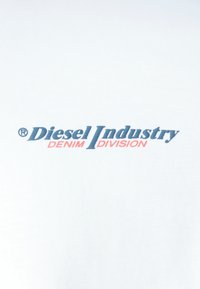 Tessuto bianco con testo blu e rosso che recita "Diesel Industry DENIM DIVISION," con il simbolo di marchio registrato.