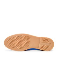 Semelle d'une chaussure avec semelle extérieure en caoutchouc couleur tan présentant des motifs de bande de roulement diagonaux et géométriques texturés, partie supérieure bleue partiellement visible.