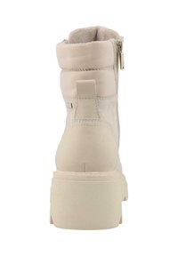 Stivale alla caviglia beige chiaro con collo imbottito, chiusura con zip, texture in pelle liscia e suede, e suola chunky e testurizzata.