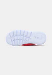 Suola di scarpa Nike caratterizzata da una texture in gomma bianca con fessure flessibili, un motivo dettagliato e un accento rosso nel tallone.