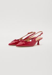 Décolleté in pelle vernice rossa con punta affilata, piccoli fiocchi sulla parte anteriore e un tacco a kitten leggero. Texture liscia e design elegante.