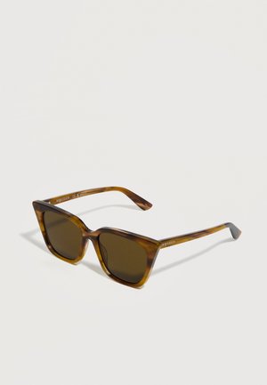 Tortoise shell cat-eye sunglasses with dark lenses and slim arms featuring subtle logo text on the temples.