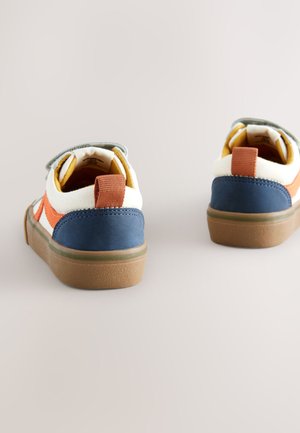 To børnesneakers lavet af lærred, med en farvepalet i blå, hvid og orange, med velcrolukning og teksturerede gummisåler.