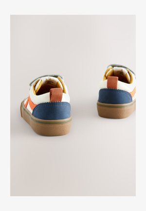 Kaksi lasten kangaslenkkaria, joissa on sinivalkooranssi värimaailma, tarrakiinnikkeet ja kuvioidut kumipohjat.