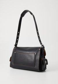 Sac à main en cuir noir avec une bandoulière simple et une poche avant. Présente des coutures contrastées et des accents en matériel argenté. Design compact et structuré.