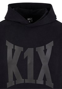 Czarna bluza z kapturem z dużym szarym logo "K1X" na przodzie. Wykonana z miękkiego materiału. Posiada kaptur ze sznurkiem i luźny krój.