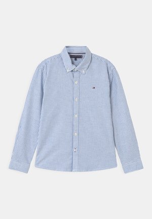 Blau-weiß gestreiftes Hemd mit Knöpfen, langen Ärmeln, Kragen und einem kleinen Logo auf der Brust. Hergestellt aus einem glatten Stoff.