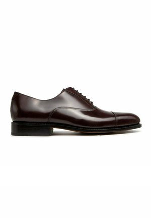 Chaussure Oxford en cuir marron foncé poli avec laçage fermé, bout droit et talon bas empilé, présentée de profil sur fond blanc.