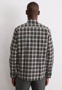 Geruite shirt in donkergrijs, wit en olijfgroen. Zachte stof, lange mouwen en een klassieke kraag met een yoke-detail op de rug.