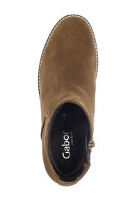 Bottine en suede beige avec un bout rond, des panneaux élastiques sur les côtés pour un bon ajustement, et une couture blanche contrastante le long de la semelle. Doublure intérieure noire.