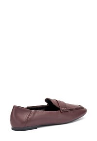 Mocasines de cuero burdeos con punta redondeada, diseño de fácil colocación, detalles de costura y una suela baja y plana para mayor estabilidad.