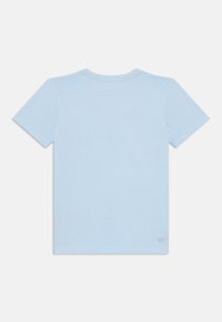T-shirt in cotone azzurro chiaro con maniche corte, scollatura rotonda e un piccolo dettaglio con logo sulla parte anteriore bassa. Tessuto morbido.