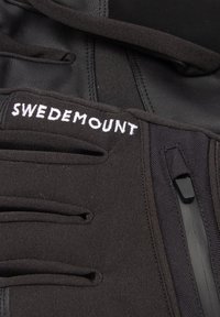 Tessuto nero con una texture liscia, con il logo "SWEDEMOUNT" in bianco, spallacci regolabili e una tasca con zip sul lato.