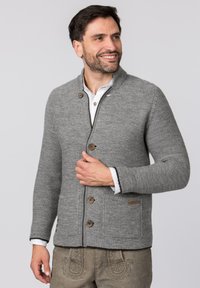 Grauer Strickcardigan mit Schalkragen, ausgestattet mit Holzknöpfen, zwei vorderen Taschen und einer strukturierten Oberfläche. Akzente sind der kontrastierende Besatz.