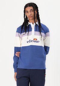 Polo de manga longa com riscas azuis, brancas e lavanda, apresentando um colarinho e um logo ellesse na parte da frente. Material em algodão.