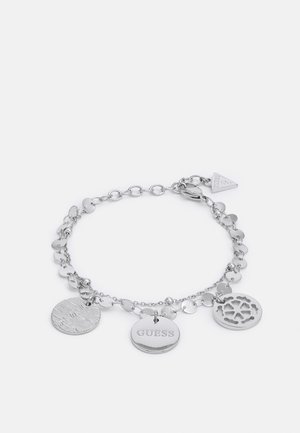 Zilveren bedelarmband met drie ronde hangers: getextureerd, gegraveerd met "GUESS" en met uitgesneden bloemmotief, beveiligd met een karabijnsluiting.