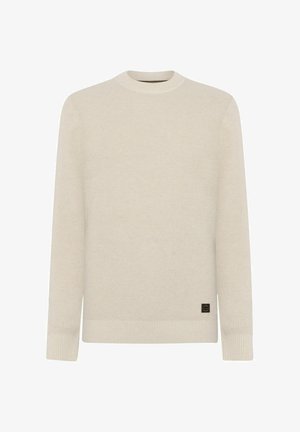 Pull en maille beige à manches longues, avec des poignets et un ourlet côtelés, un col rond, et une petite étiquette de marque noire et brune près de l'ourlet inférieur.
