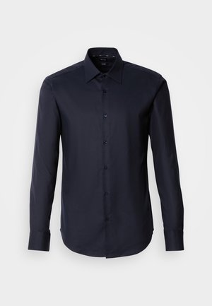 Chemise à boutons à manches longues bleu marine foncé, fabriquée en tissu lisse. Elle présente un col pointu et des poignets à un bouton. Design minimaliste sans motifs.