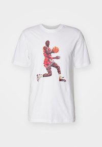 Camiseta blanca de manga corta con un gráfico pixelado de un jugador de baloncesto en uniforme rojo saltando y sosteniendo un balón de baloncesto naranja.
