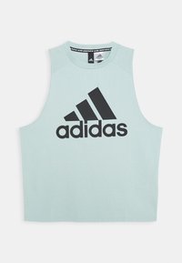 Top senza maniche color verde menta chiaro realizzato in tessuto morbido, con un logo Adidas nero sul davanti e una scollatura rotonda.