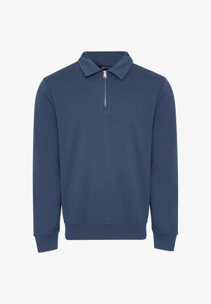 Suéter azul marino con cuello con cremallera, mangas largas y puños y dobladillo acanalados. Fabricado con un tejido suave y ligero de textura lisa.