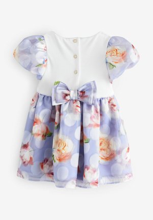 Blumenkleid mit einem weißen Oberteil, lila Rock mit runden Pünktchen und Puffärmeln. Mit einer passenden Schleife an der Taille akzentuiert.