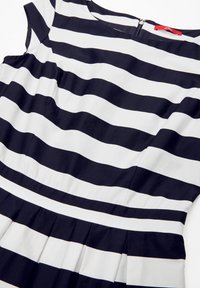 Gestreiftes Kleid in Marineblau und Weiß mit kurzen Ärmeln, plissiertem Saum und einem Reißverschluss auf der Rückseite. Der Stoff wirkt glatt und hat kräftige horizontale Streifen.